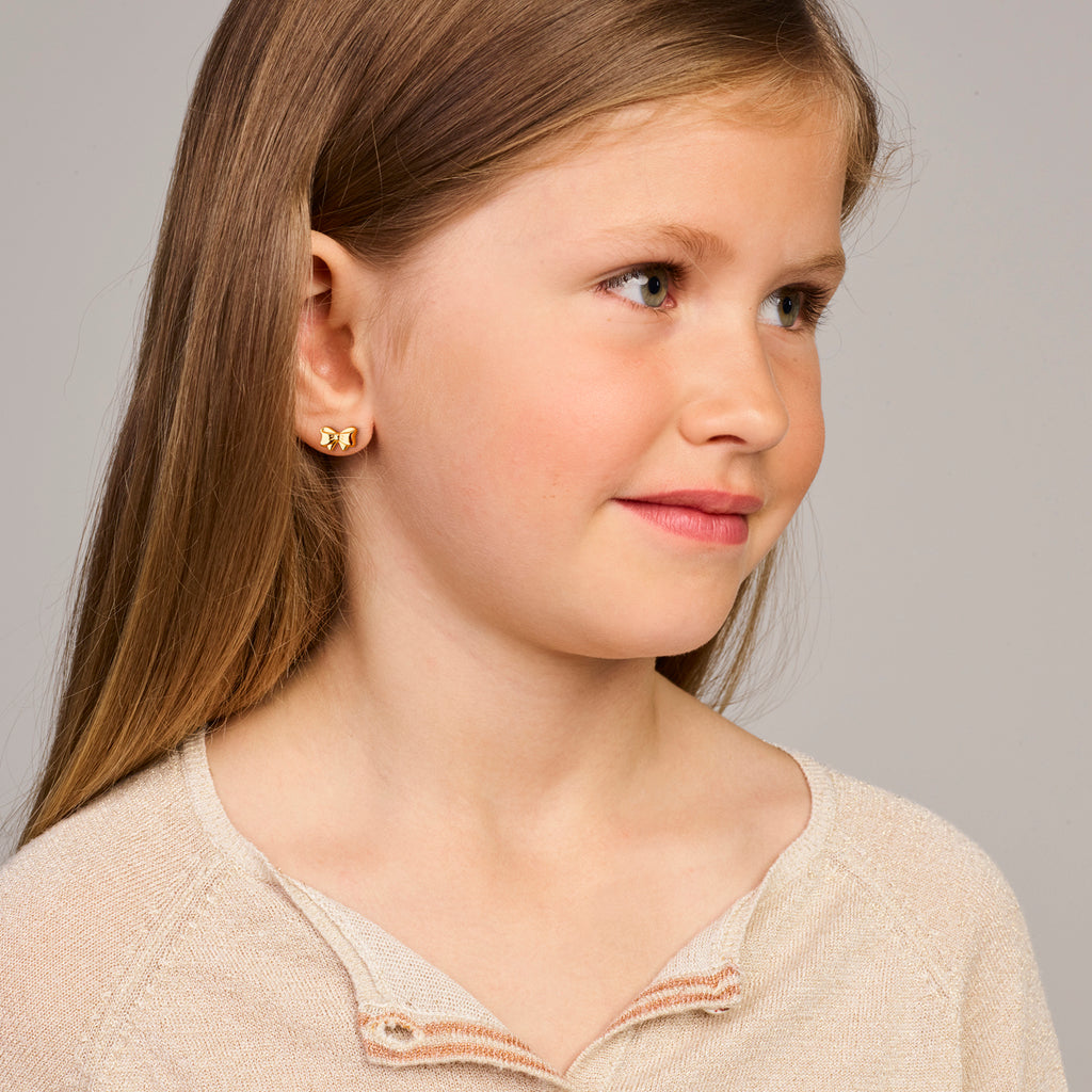 Close-up van 14K gouden oorknoppen met strik detail voor meisjes - City Juwelier