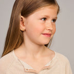 Close-up van 14K gouden oorknoppen met strik detail voor meisjes - City Juwelier