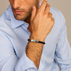 Close-up van zwarte leren armband met stainless steel sluiting voor mannen